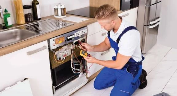 Technician examining a dishwasher control panel and wiring