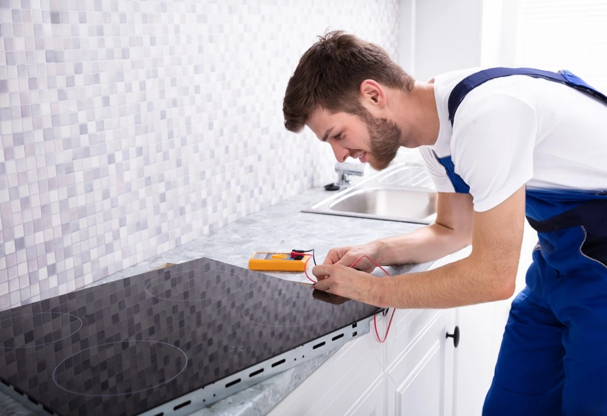 Technician testing an electric glass cooktop in a home kitchen