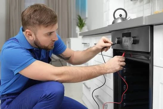 Technician testing an oven control panel with a multimeter